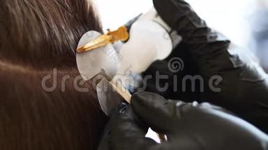 一个理发师正在安装头发延伸的<strong>升级</strong>。